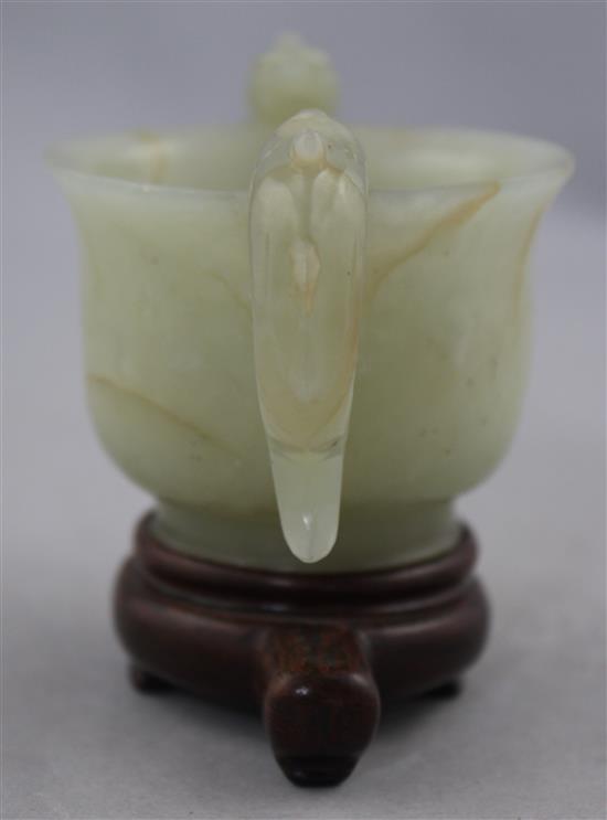 A Chinese bowenite jade two handled cup, Ming dynasty or later, 10.8cm., wood stand